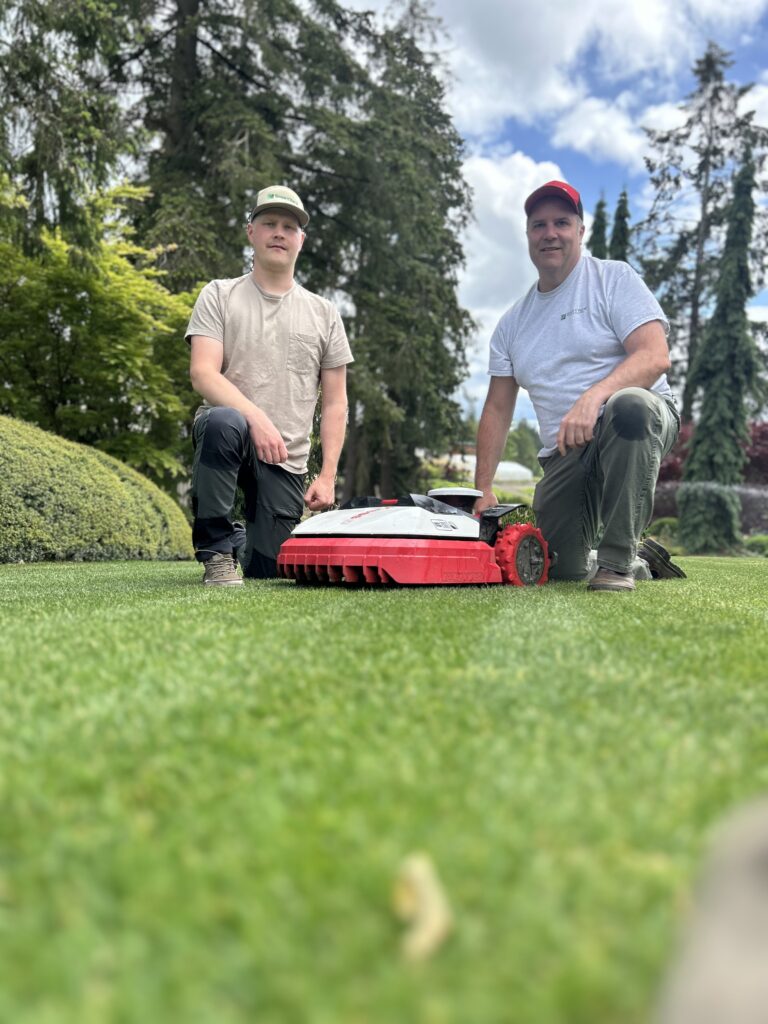SmartYard team operating a robotic lawn mower in a residential yard